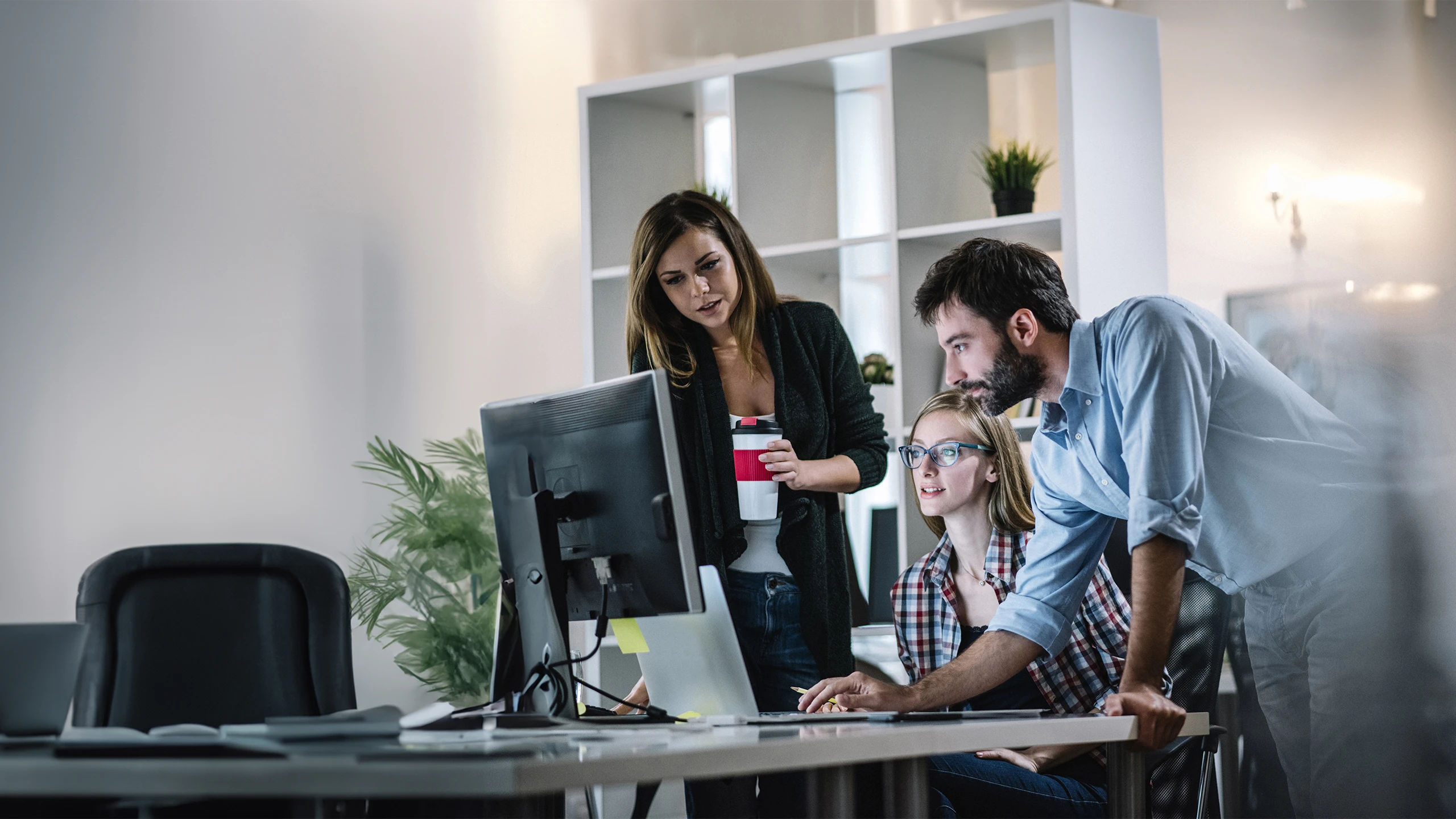 mehrere Personen schauen interessiert auf einen Bildschirm 